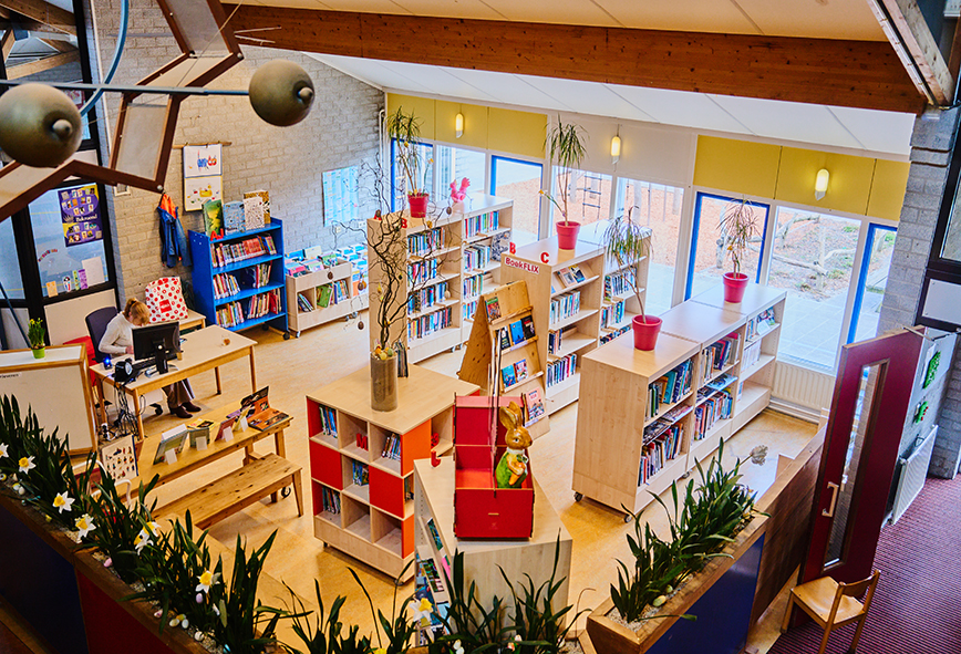 Een vogelperspectief van de bibliotheek met verschillende kasten met vakken met daarin boeken