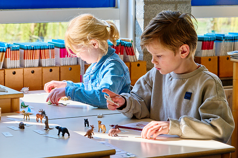 AdB_Samenwerken_3 Twee leerlingen die aan het werk zijn aan een tafeltje.