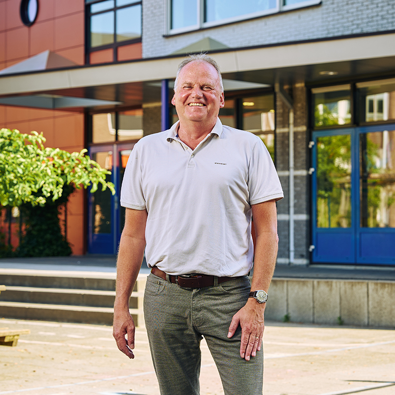 Directeur Arjan staat voor de school.