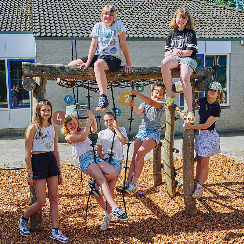 Leerlingen van de bovenbouw poseren op het klimrek van de school.