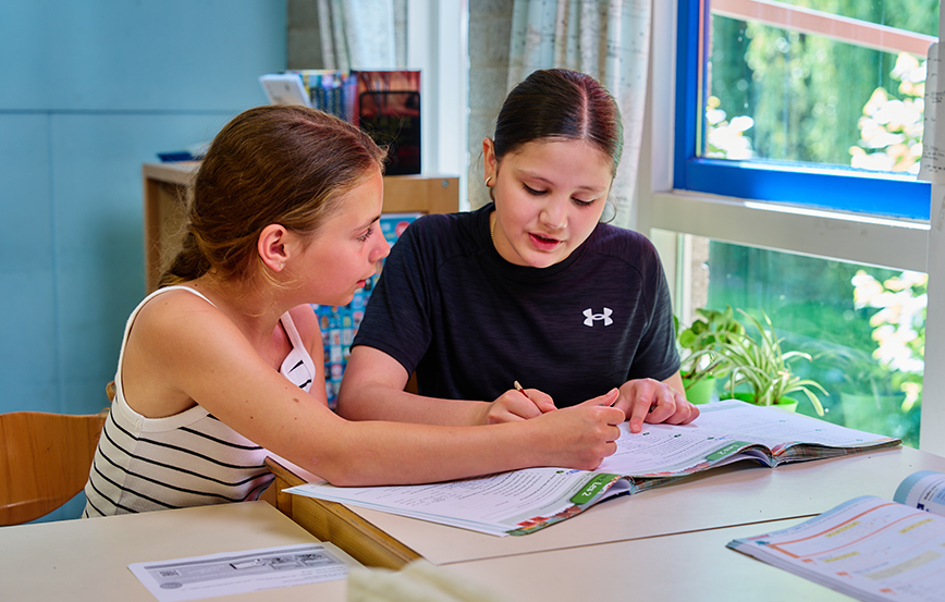 Samen aan het werk Twee leerlingen werken samen aan hun schoolwerk.
